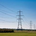 High-voltage electricity transmission lines across a landscape